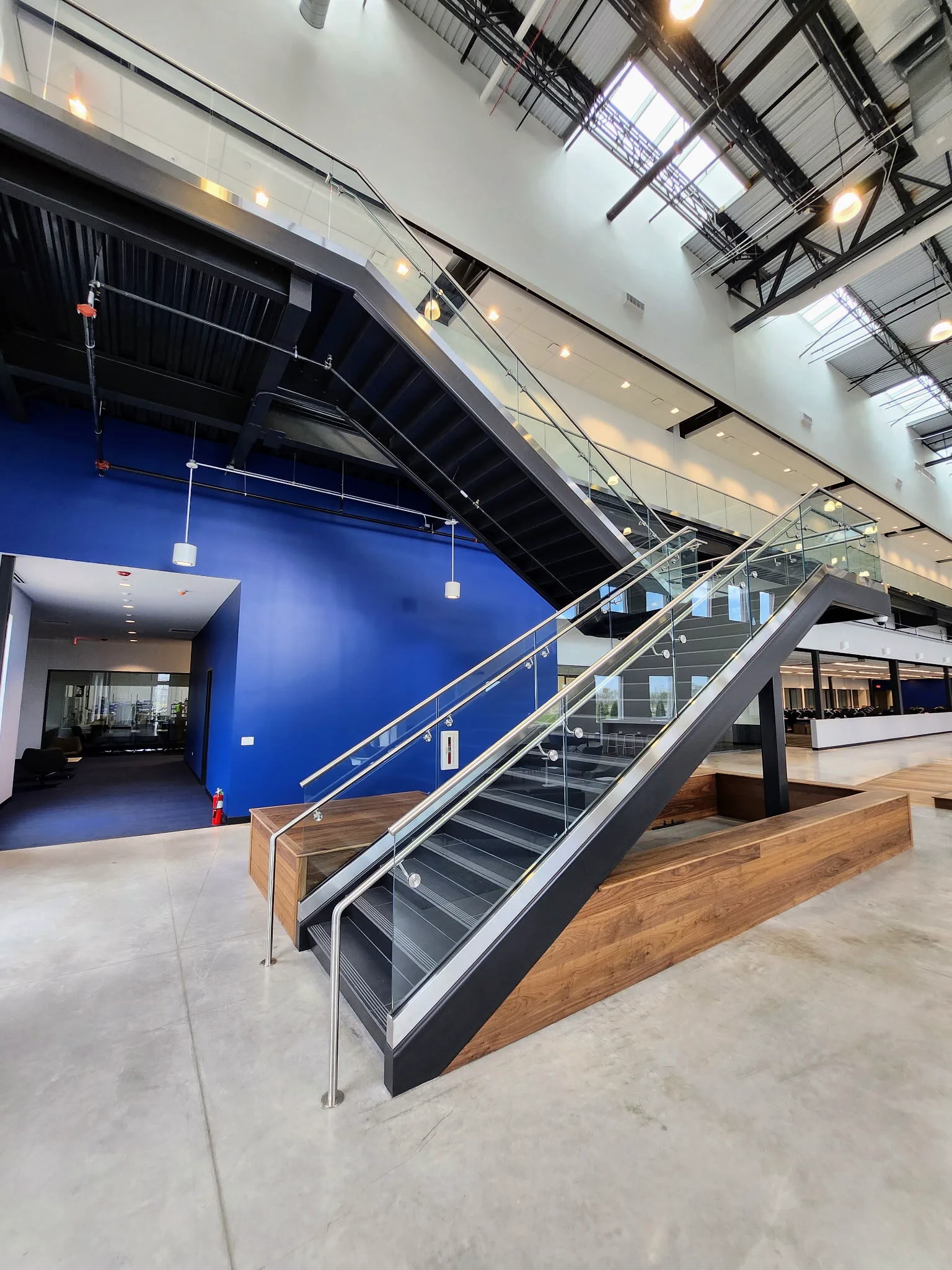 Interior staircase with glass railing and steel supports